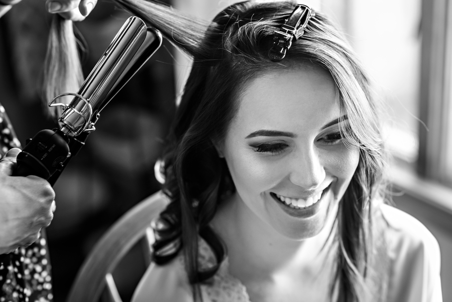 A happy bride getting her hair done before the wedding ceremony in Bucks County.